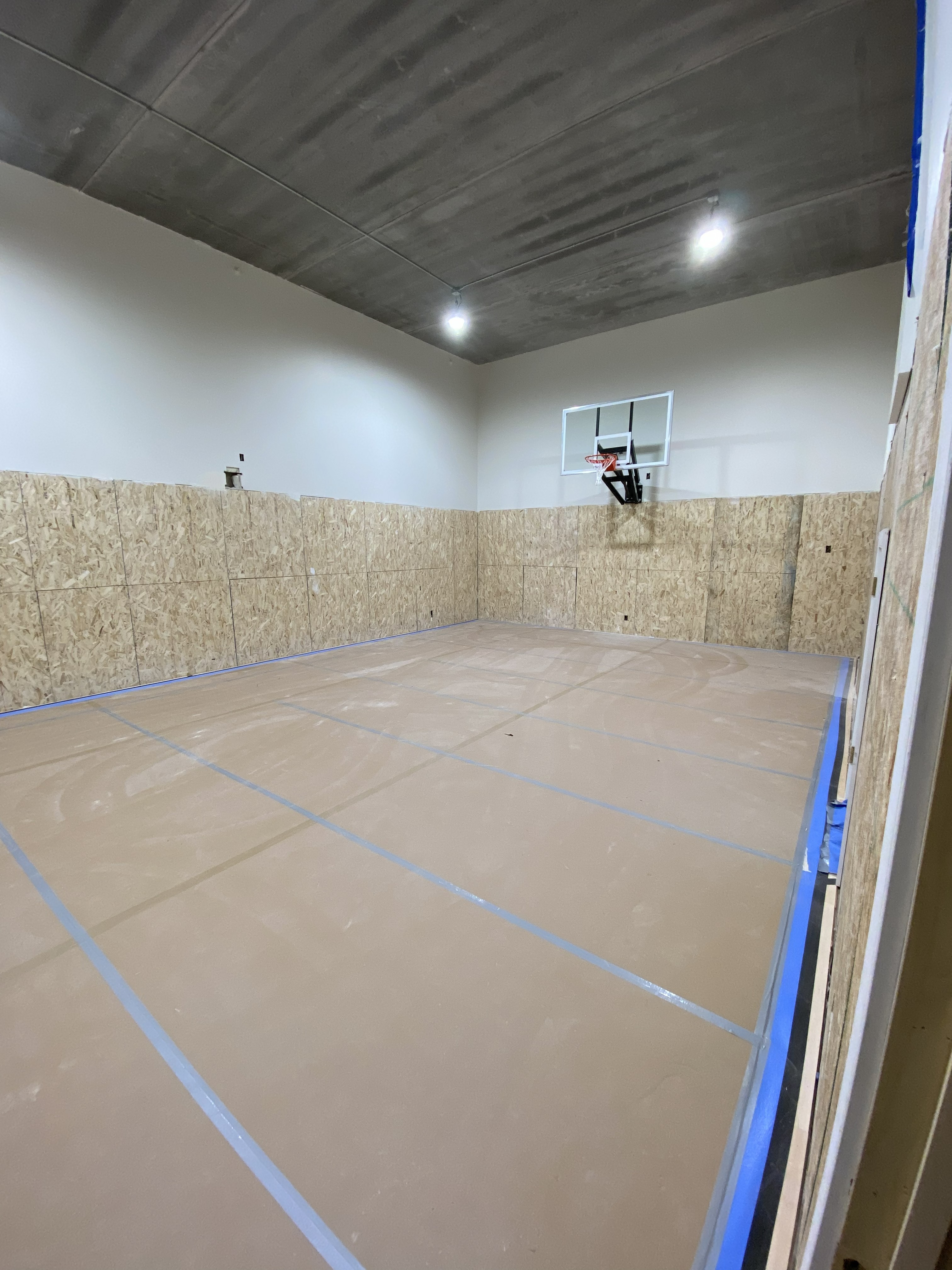 Temporary floor protection installed across a large active construction space