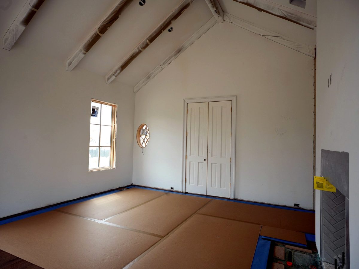 Full-room floor protection installed across finished surfaces in an active custom home